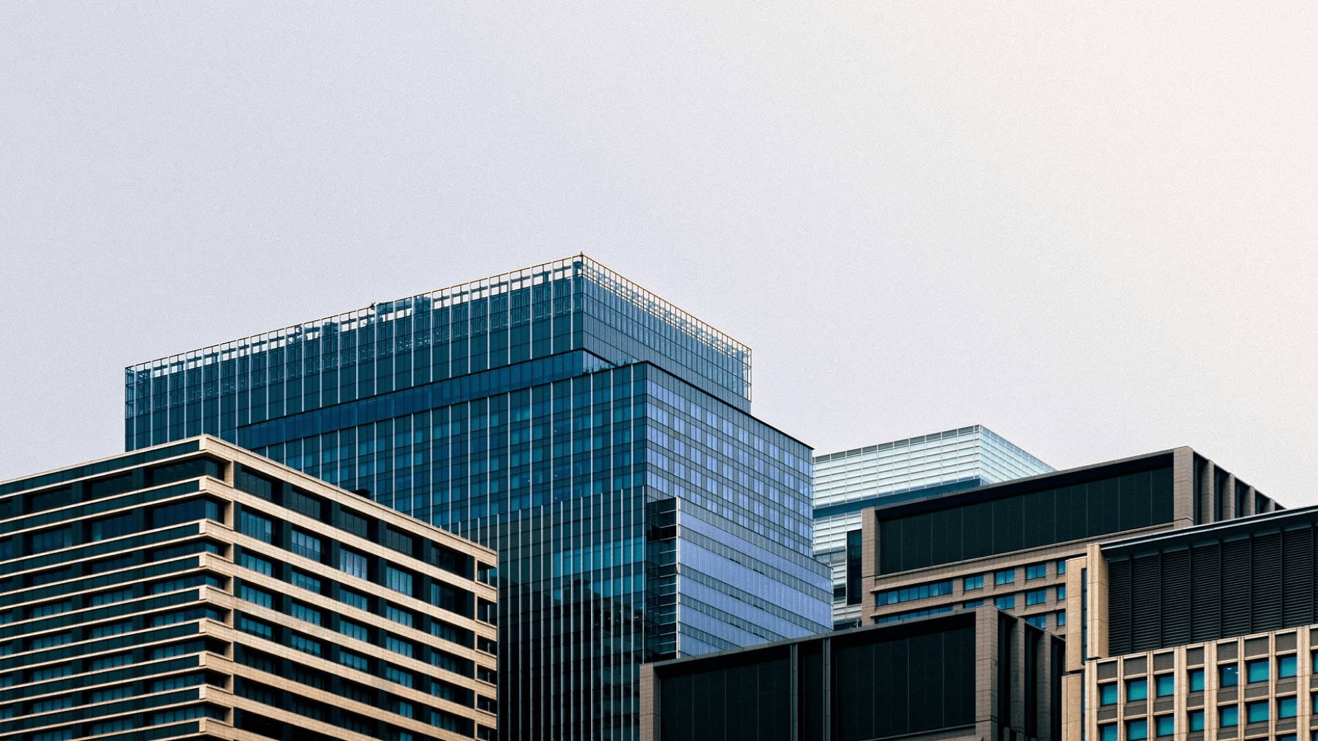 Modern glass office buildings representing a corporate hub for CX software solutions, set against a clear sky.
