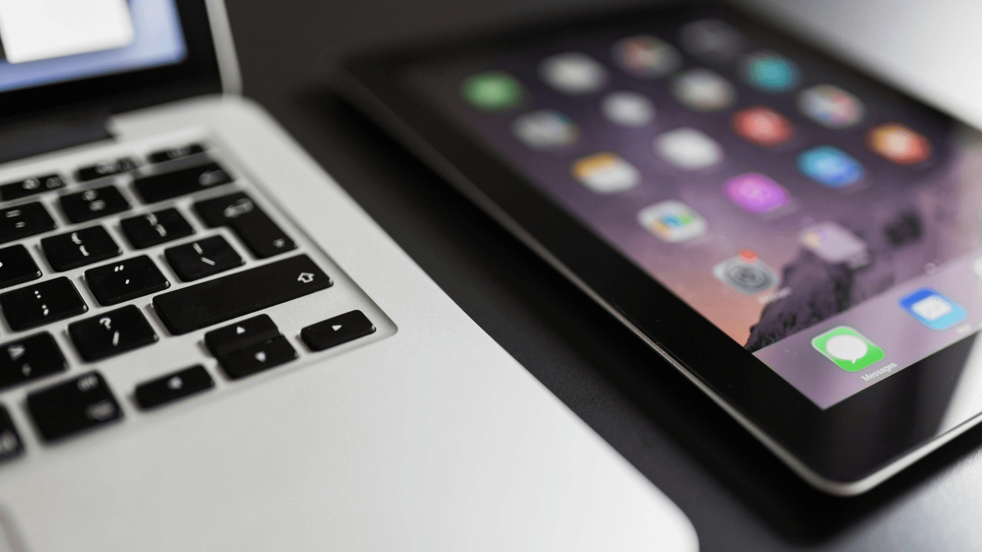 A close-up view of a laptop and tablet, illustrating the integrated digital experience a subscription-based SaaS must manage to retain customers.