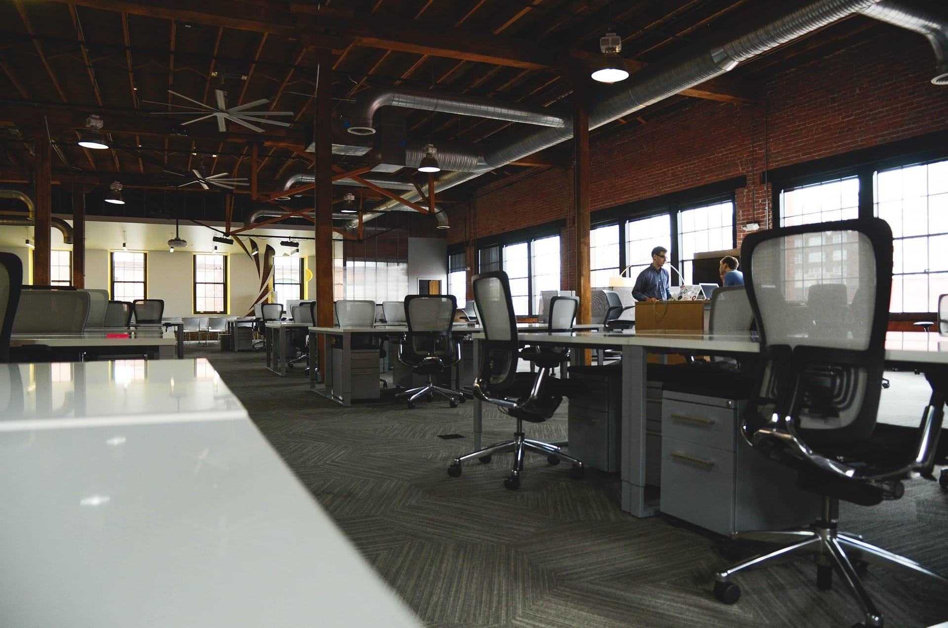 A wide-angle view of a modern industrial open-plan office space, perfectly capturing the scaling environment of a growing SaaS startup.